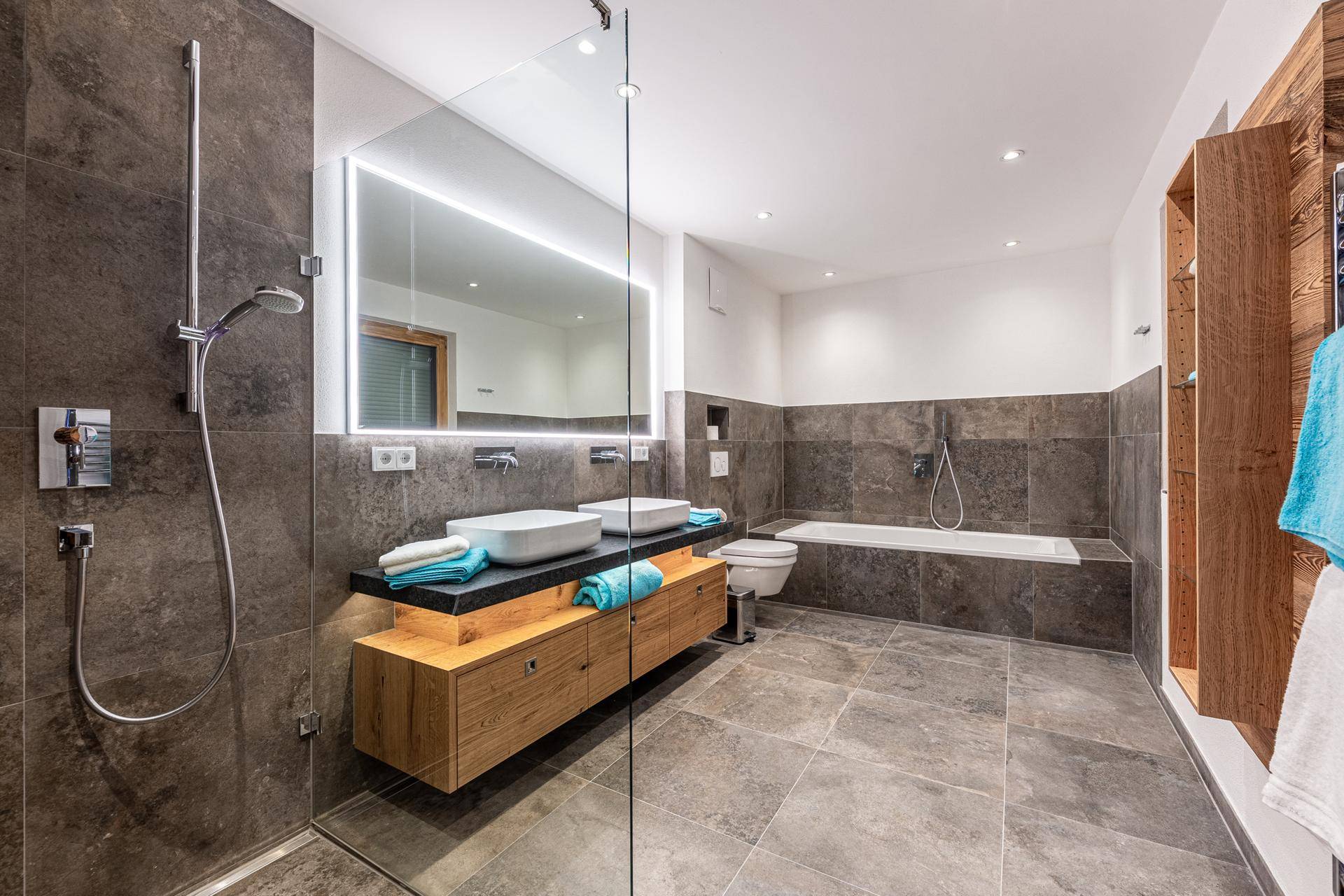 Modernes Badezimmer mit Doppelwaschbecken, begehbarer Dusche und Badewanne.