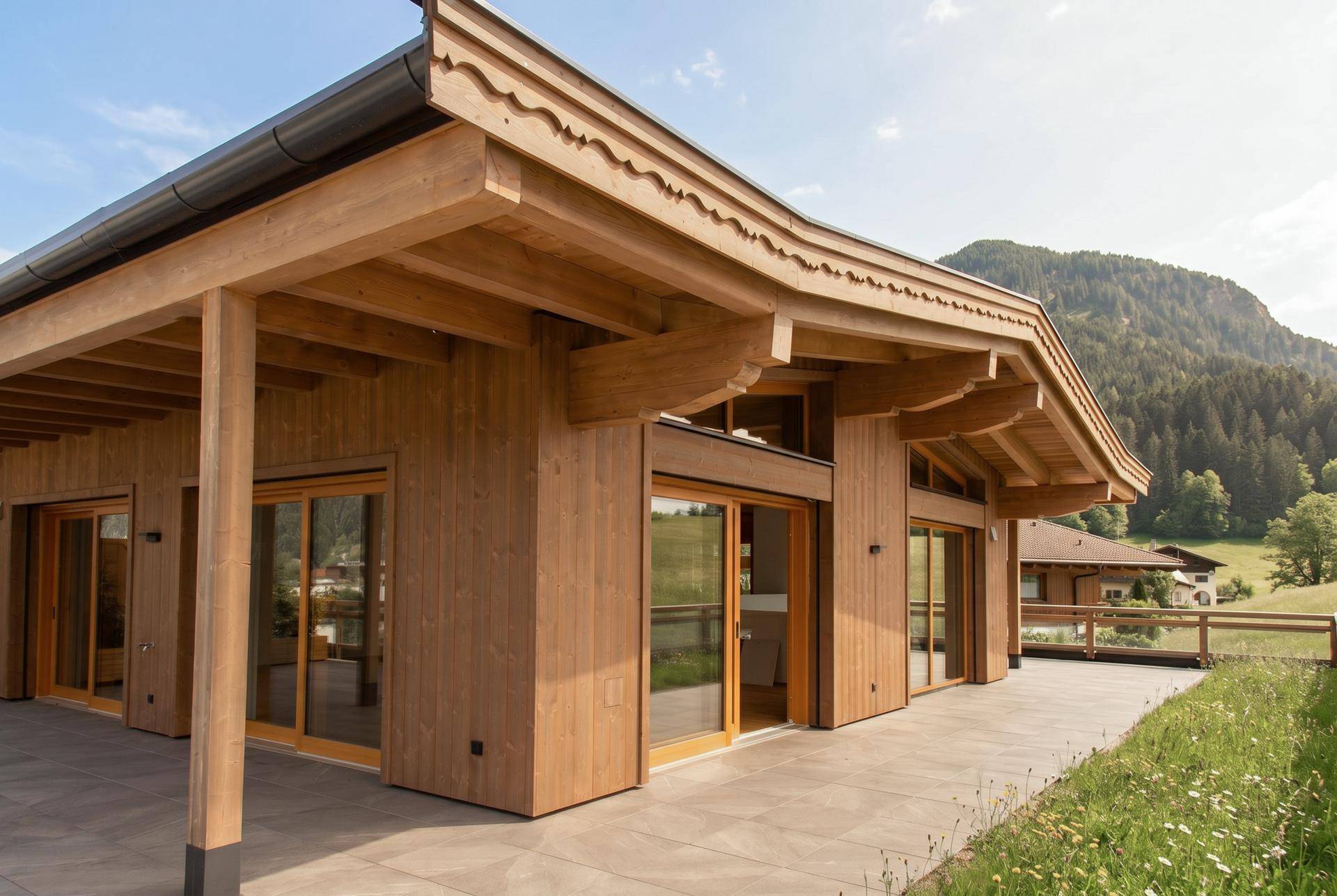 Attraktive Holzfassade des Gebäudes mit großer Terrasse und Zugang zum Gartenbereich.