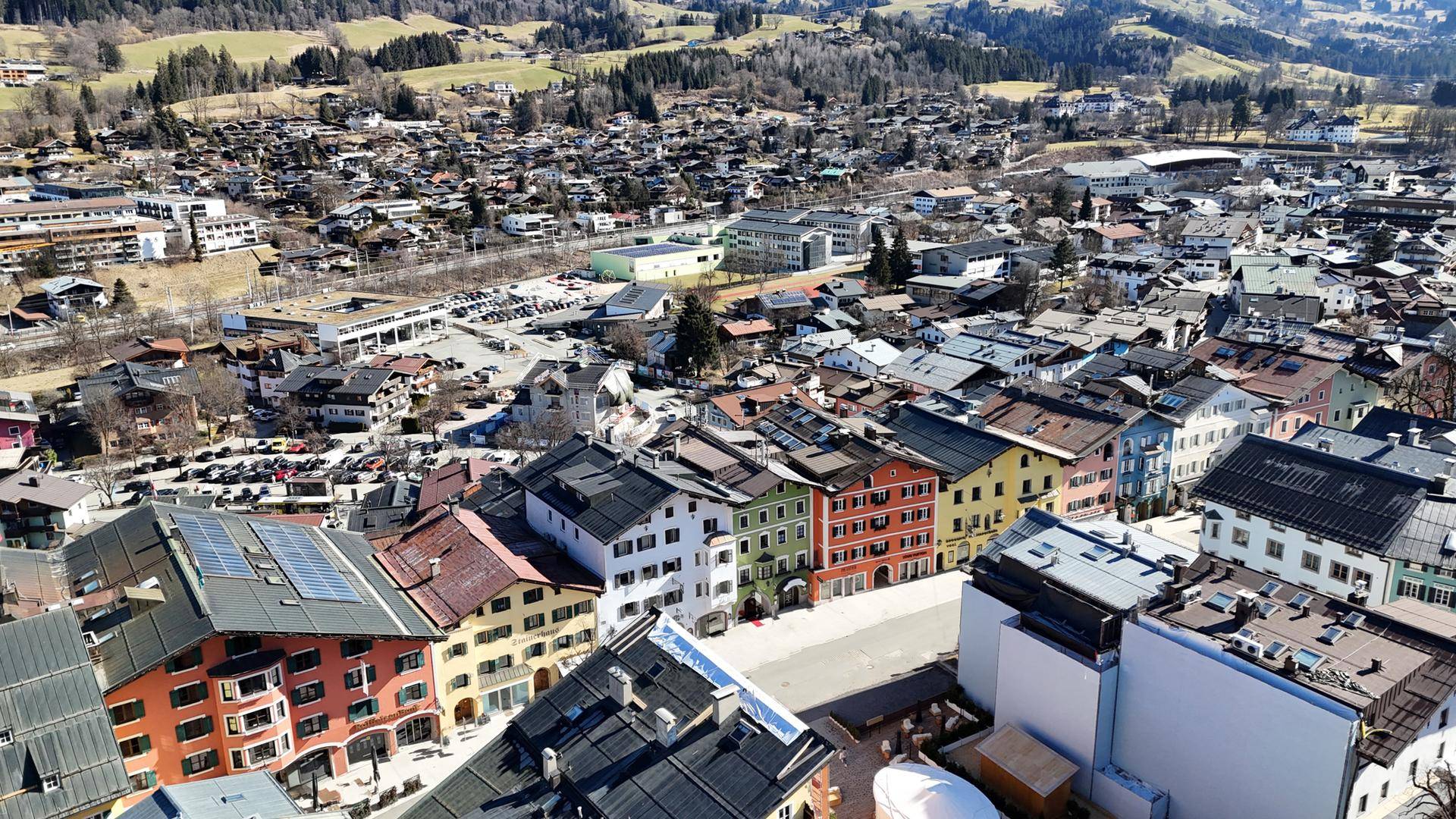 Nahaufnahme einer alpinen Stadt aus der Vogelperspektive mit bunten Häusern und Dächern.
