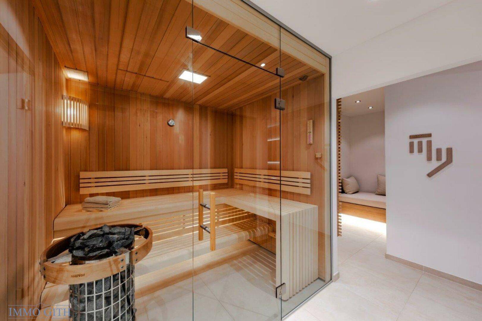 Geräumige Holzsauna mit Glasfront und angrenzendem, beleuchtetem Ruhebereich.
