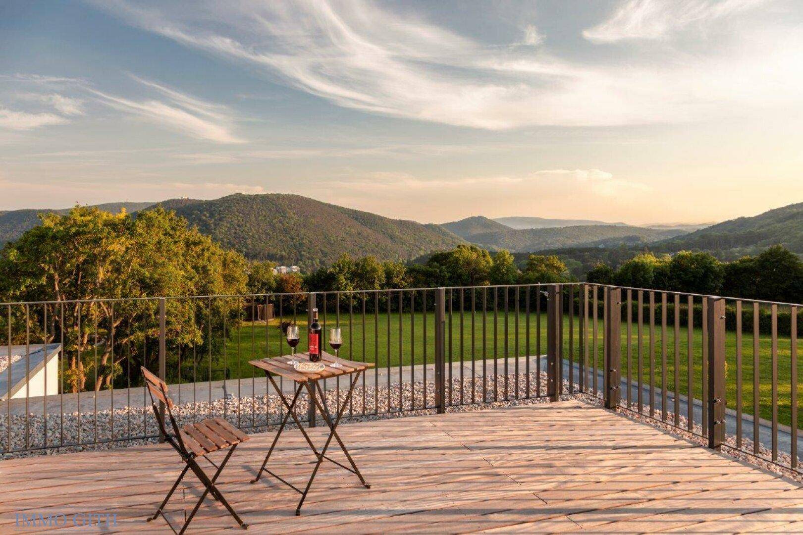 Große Dachterrasse mit Holzboden, Sitzgelegenheiten und weitem Blick auf die Berge.