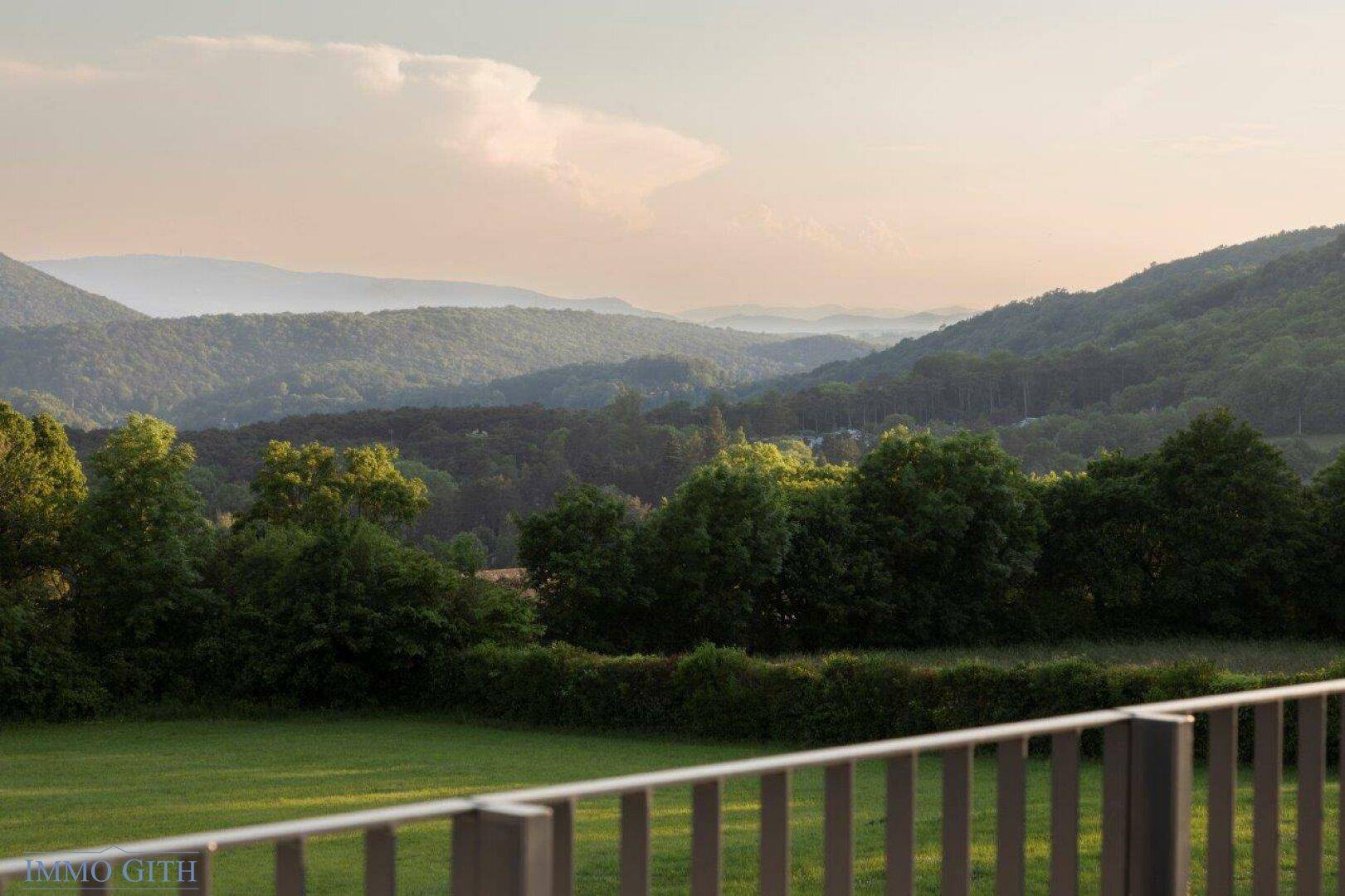 Malerischer Ausblick auf die bewaldete Hügellandschaft bei Sonnenuntergang.
