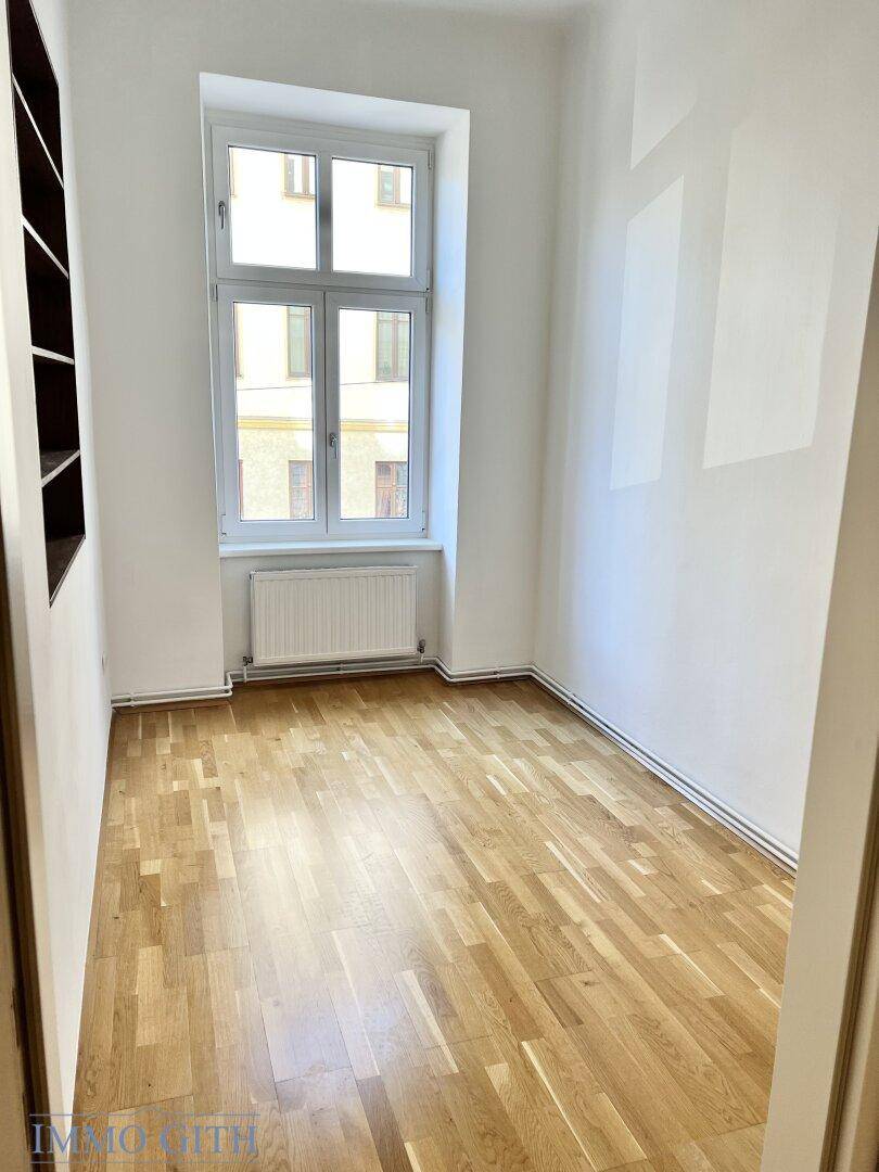 Kleines, helles Zimmer mit Parkettboden und einem Fenster, ideal als Schlaf- oder Arbeitszimmer.