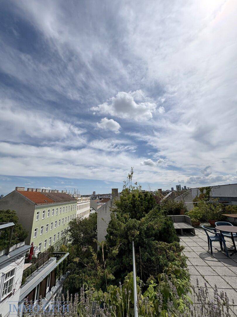 Weitläufige Dachterrasse mit Pflanzen und Panoramablick über die Stadtlandschaft.