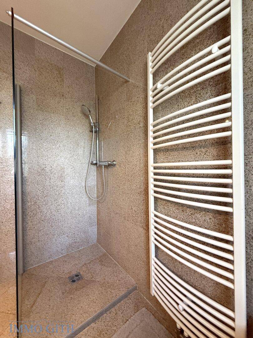 Begehbare Dusche mit Glasabtrennung und modernen Fliesen im Badezimmer.