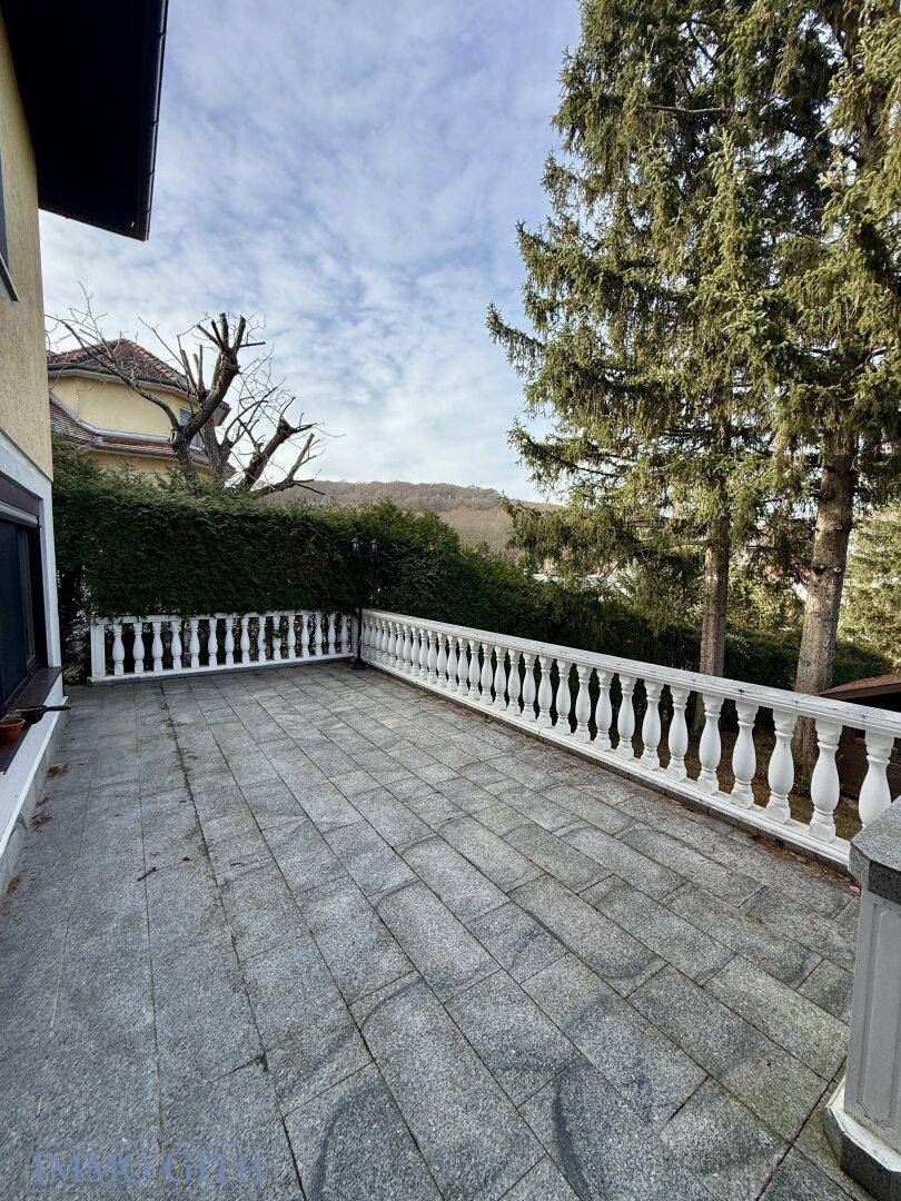 Große Steinterrasse mit Balustrade und Blick ins Grüne.