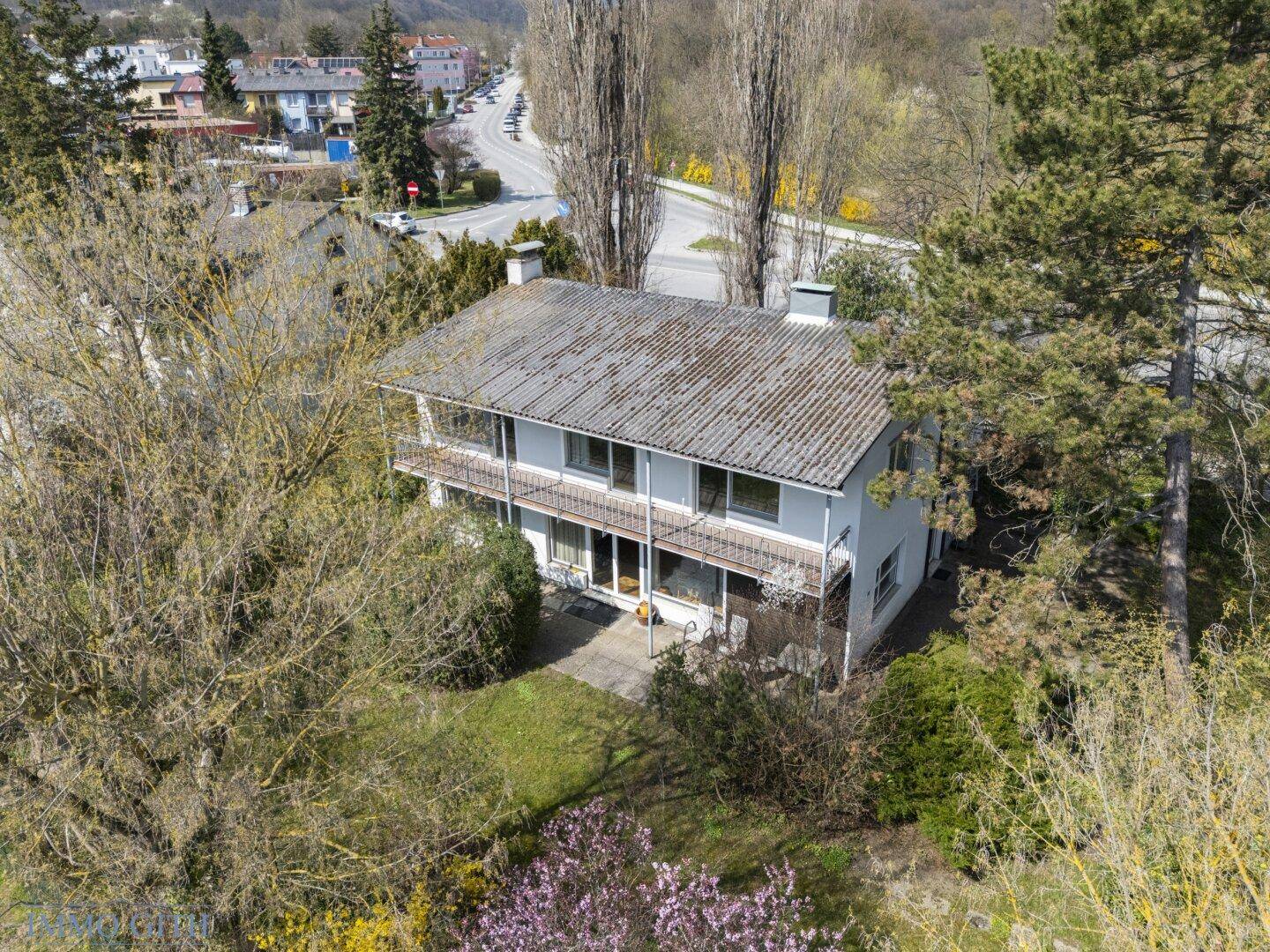 Vogelperspektive des Hauses mit Balkonen, Garten und der umliegenden Wohngegend.