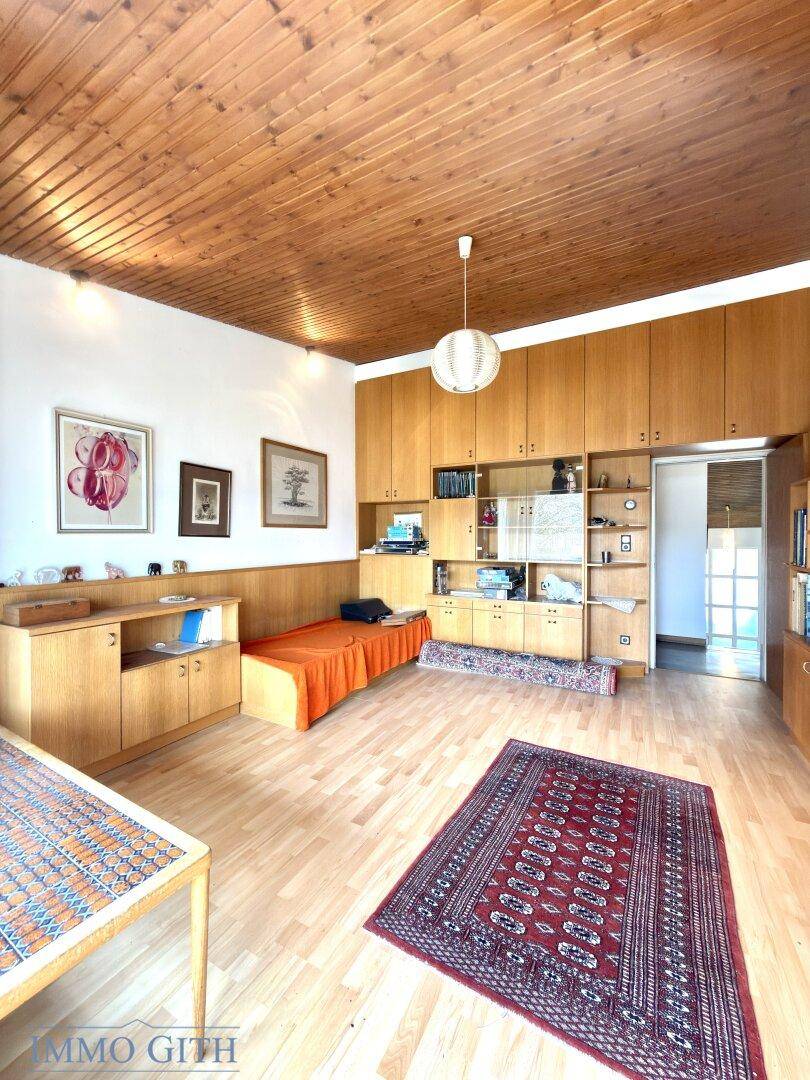 Geräumiges Zimmer mit Holzdecke, Parkettboden und großen Einbauschränken.