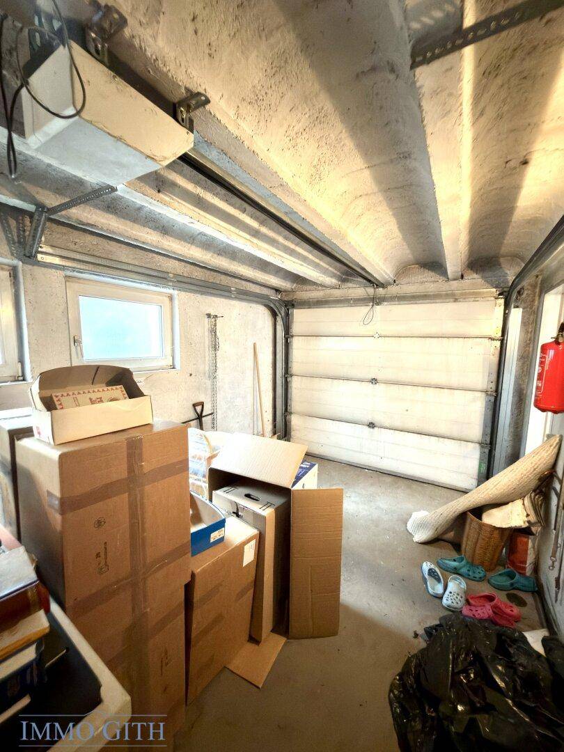 Garage mit Lagerkartons, Garagentor und einem Fenster für Tageslicht.