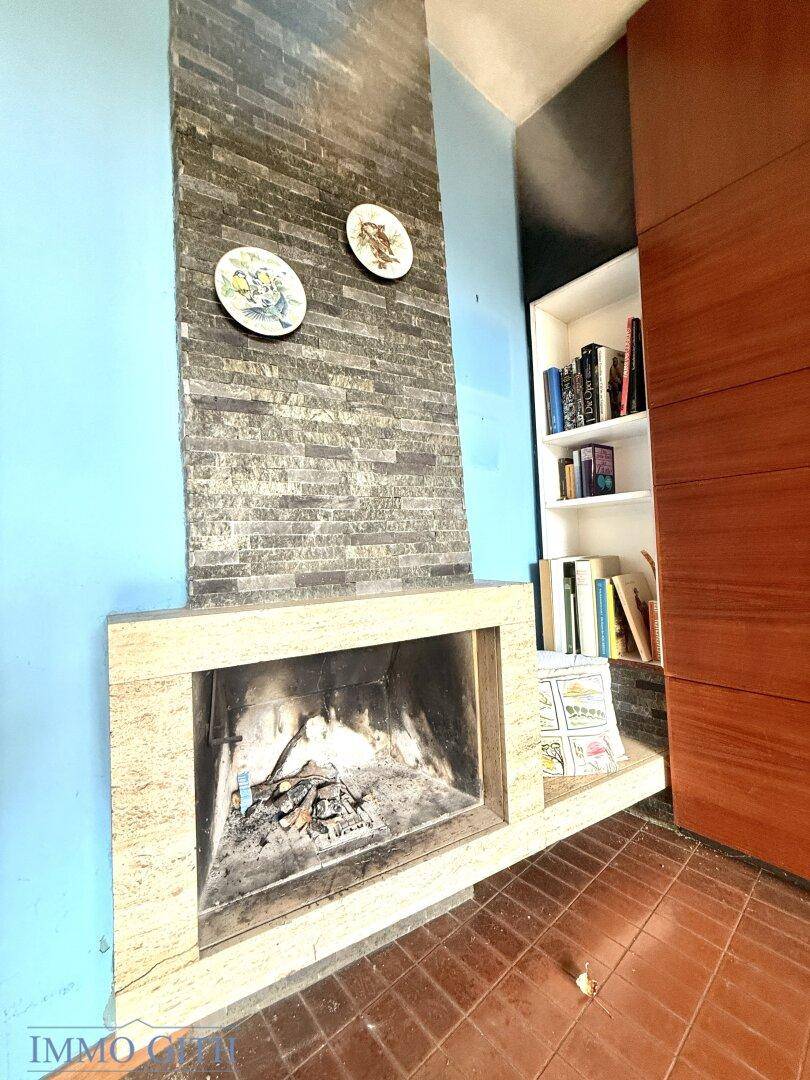 Gemütlicher Kaminbereich mit Steinverkleidung und blauer Wandfarbe im Wohnzimmer.