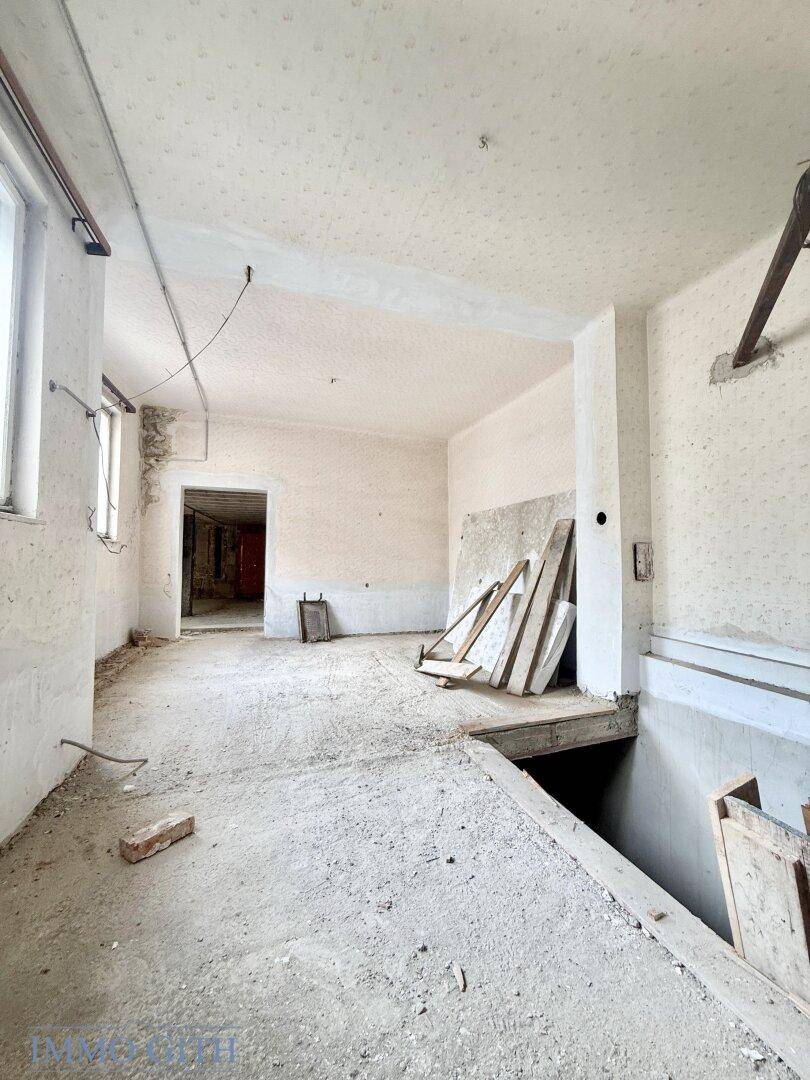 Unfertiger Raum im Obergeschoss mit Betonboden und Blick auf einen weiteren Bereich, bereit zur Sanierung.