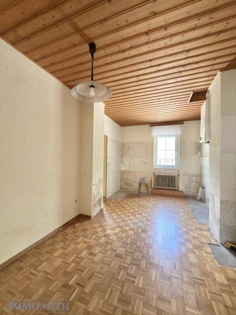 Küche mit Holzdecke und Fischgrätparkett, bereit für eine neue Einrichtung.