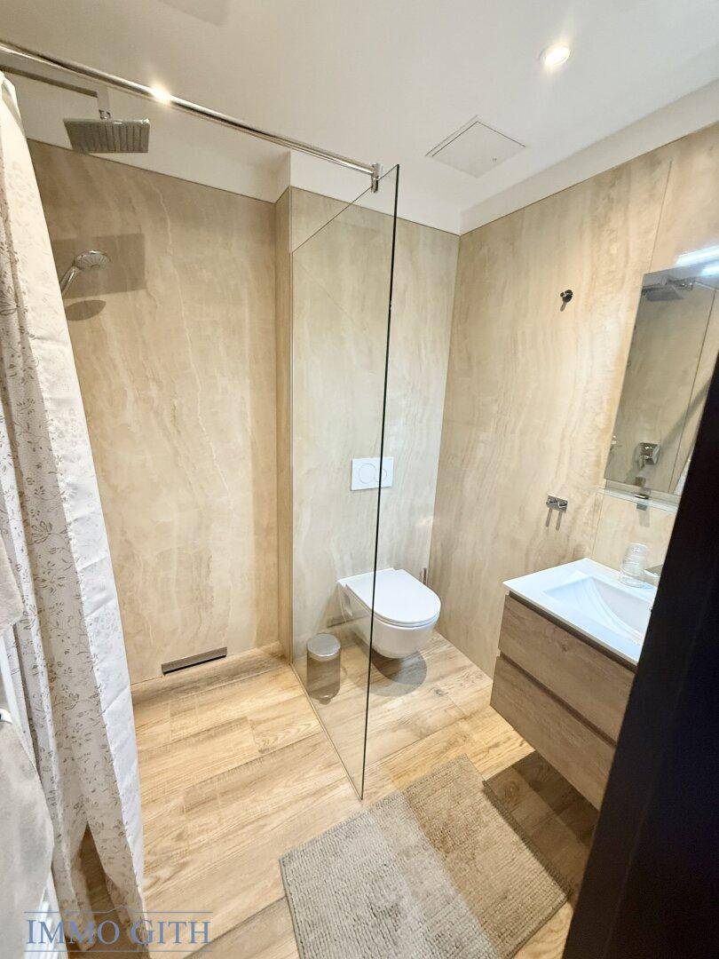 Modernes Badezimmer mit begehbarer Dusche, Wand-WC und Holzwaschtisch.