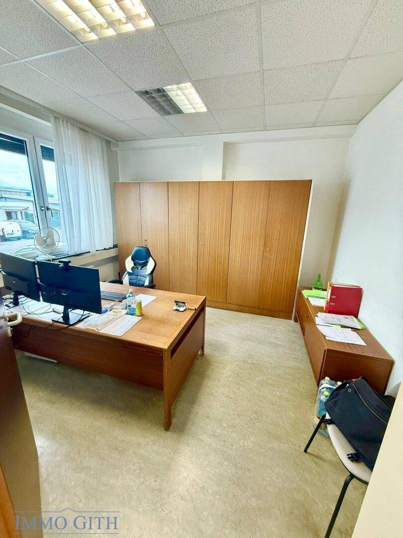 Geräumiges Büro mit einem großen Holzschreibtisch, passenden Schränken und Blick nach draußen.