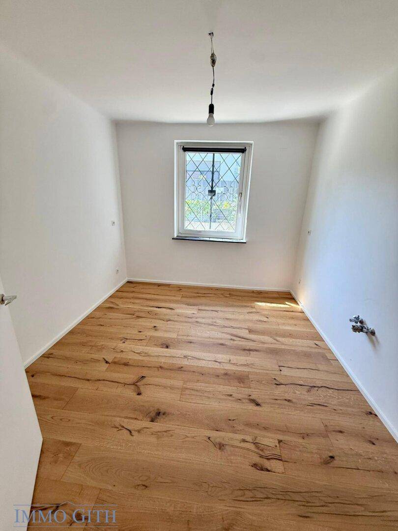 Kleinerer Raum mit Holzboden und einem Fenster, ideal als Schlaf- oder Arbeitszimmer nutzbar.