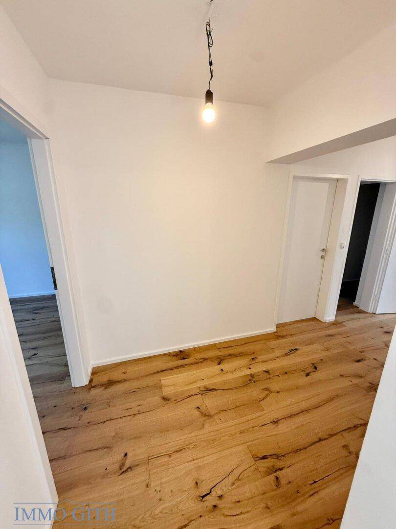 Heller Bereich mit Holzboden und Türen zu angrenzenden Zimmern, gut gepflegt und einladend.