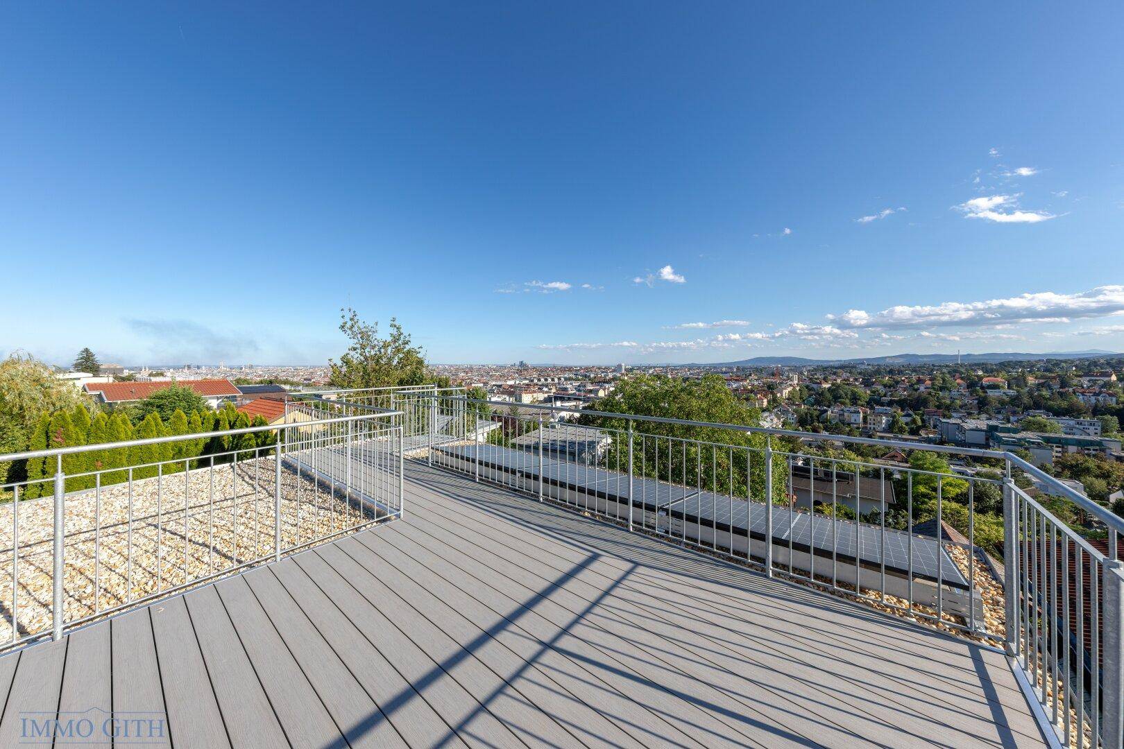 Große Dachterrasse mit modernem Bodenbelag und weitem Blick über die Stadt.