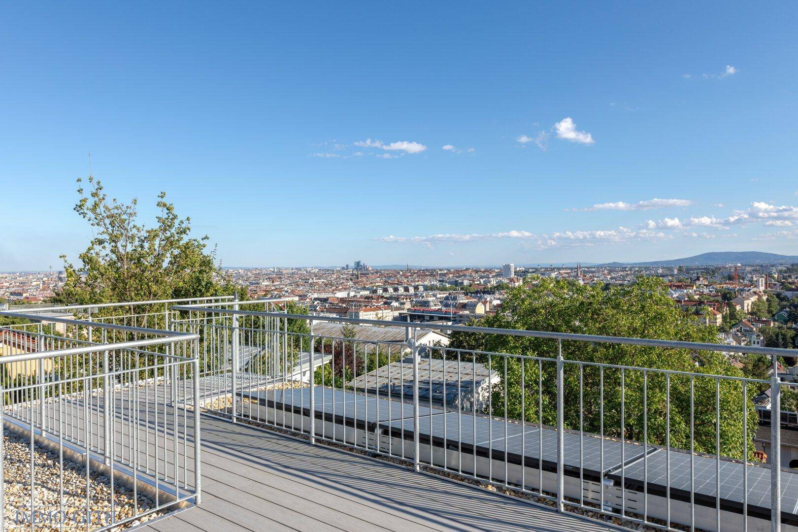 Sonniger Außenbereich mit Panoramablick auf die Stadt und die umliegende Landschaft.