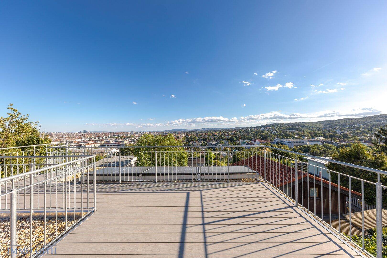 Weitläufige Dachterrasse mit beeindruckendem Ausblick auf die Stadt und die grünen Hügel.