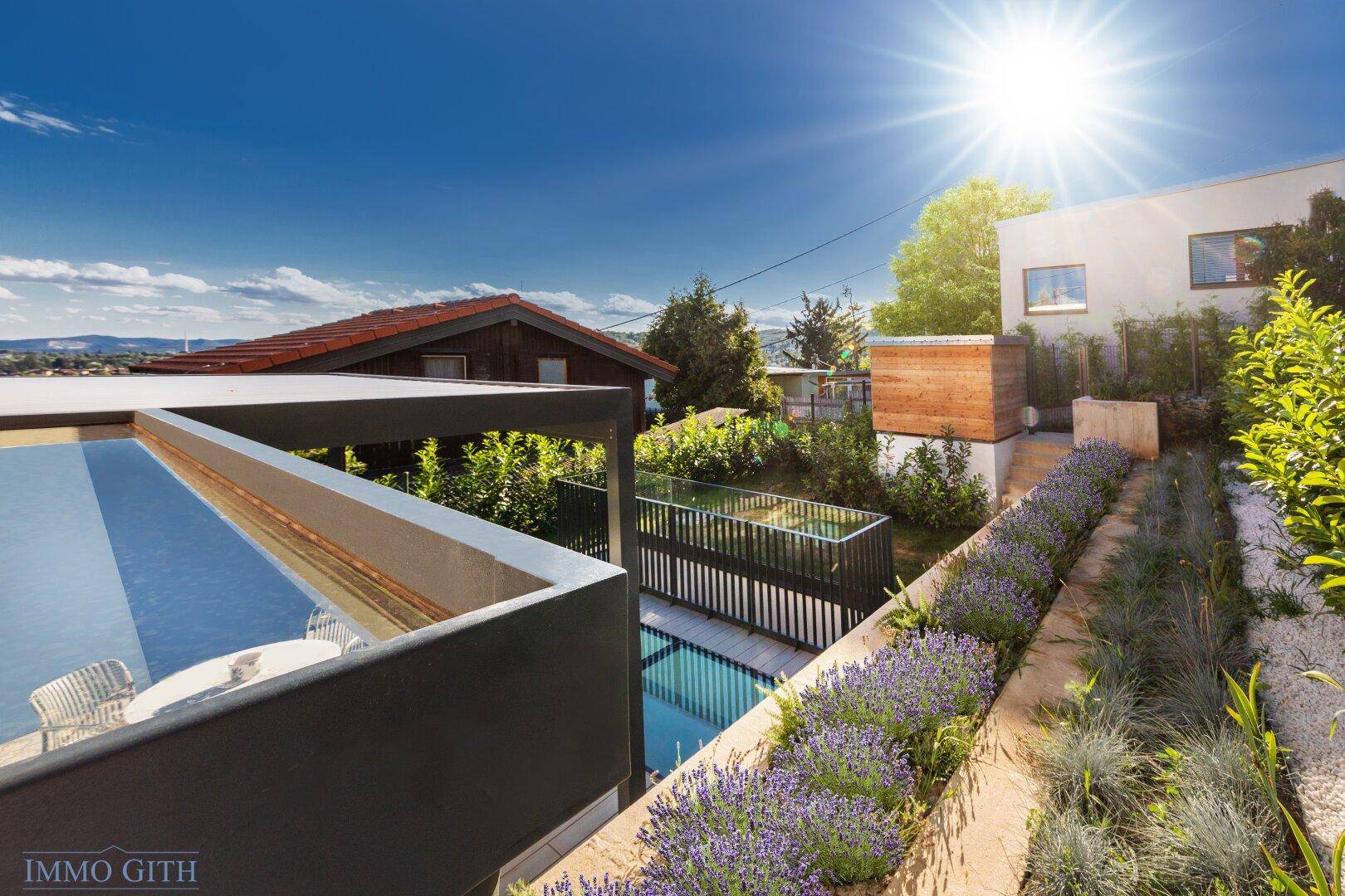 Moderner Außenbereich mit Pool, gepflegtem Garten und sonniger Atmosphäre.