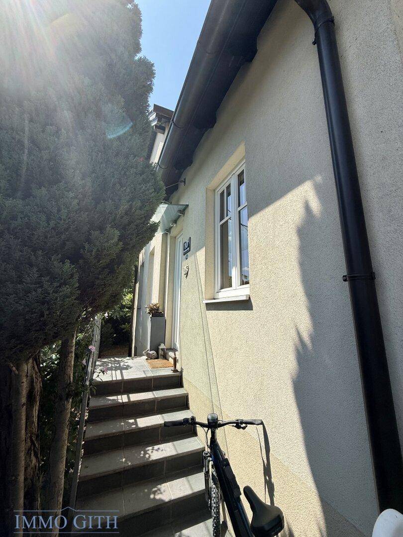 Eingangsbereich des Hauses mit Steintreppe und einem Fahrrad im Vordergrund.