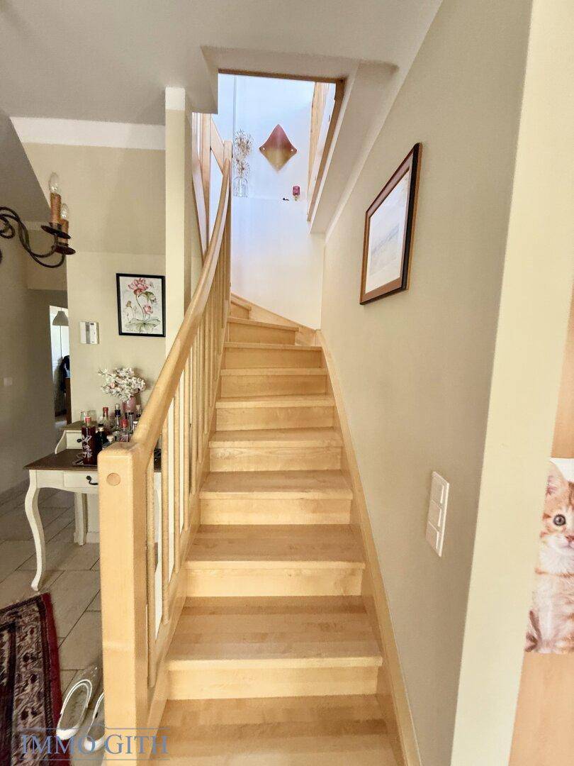 Helle Holztreppe führt in die oberen Stockwerke des Hauses.