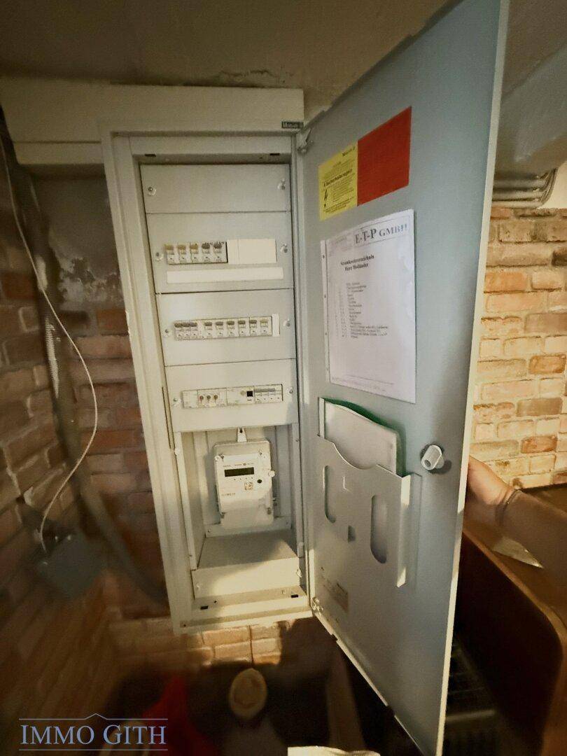 Offener Sicherungskasten und Stromzähler im Kellerbereich des Hauses.