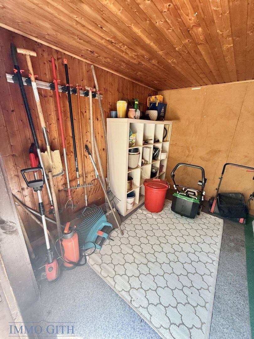 Innenansicht des Gartenhauses mit Holzverkleidung, genutzt zur Aufbewahrung von Gartengeräten.