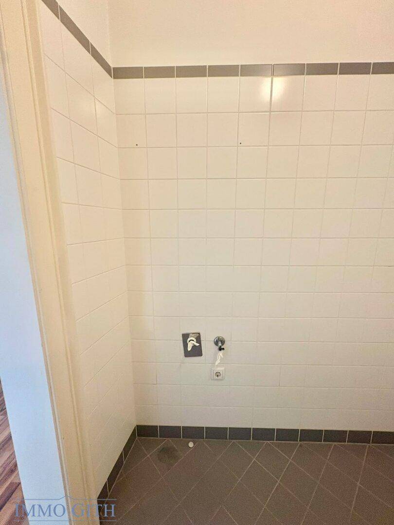 Gefliester Raum mit Anschlüssen für Waschmaschine oder Trockner.