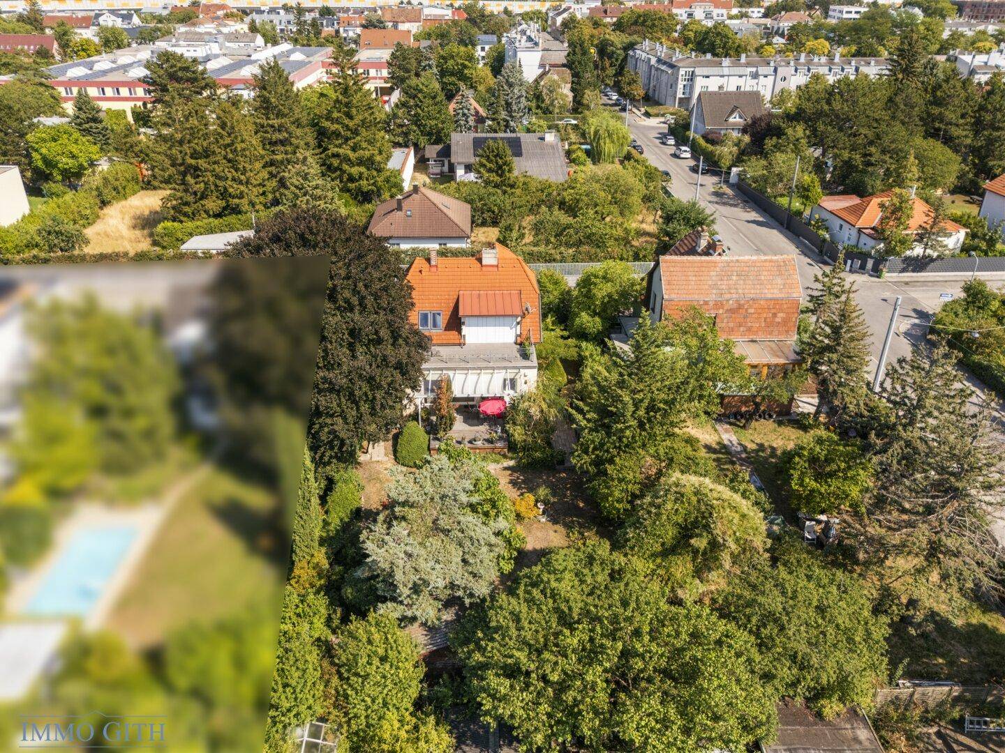 Luftaufnahme des hinteren Gartenbereichs mit viel Grün und angrenzender Nachbarschaft.