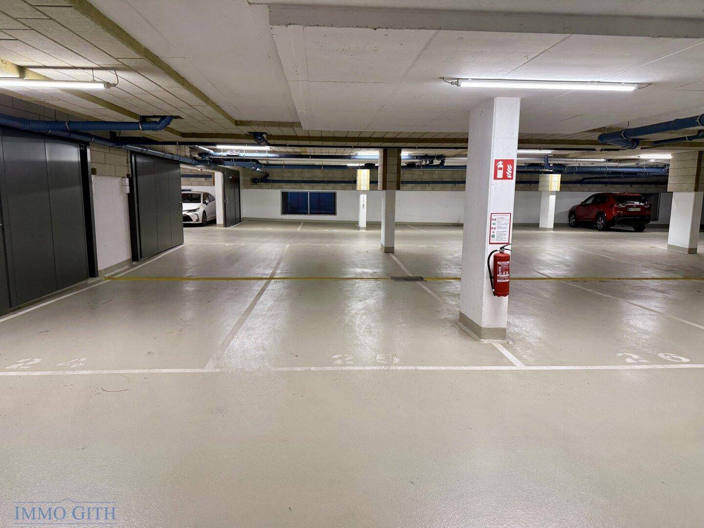 Gut organisierte Tiefgarage mit Parkbuchten und abschließbaren Abstellkammern für Bewohner.