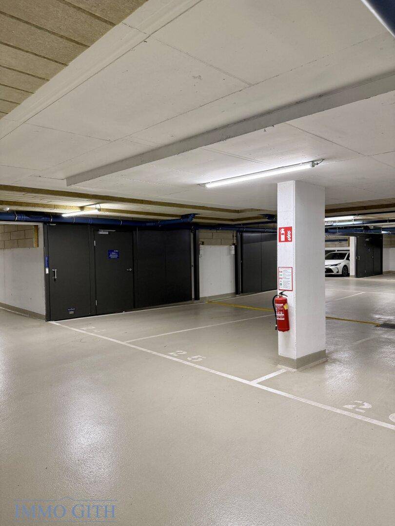 Geräumige Tiefgarage mit individuellen Abstellboxen und klar gekennzeichneten Parkflächen.