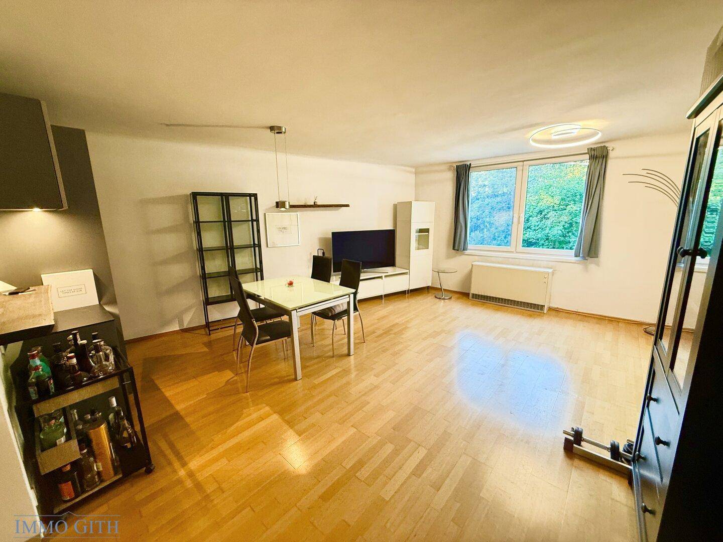 Geräumiger Wohn-Essbereich mit Parkettboden, Esstisch und Medienmöbeln, ideal für geselliges Beisammensein.