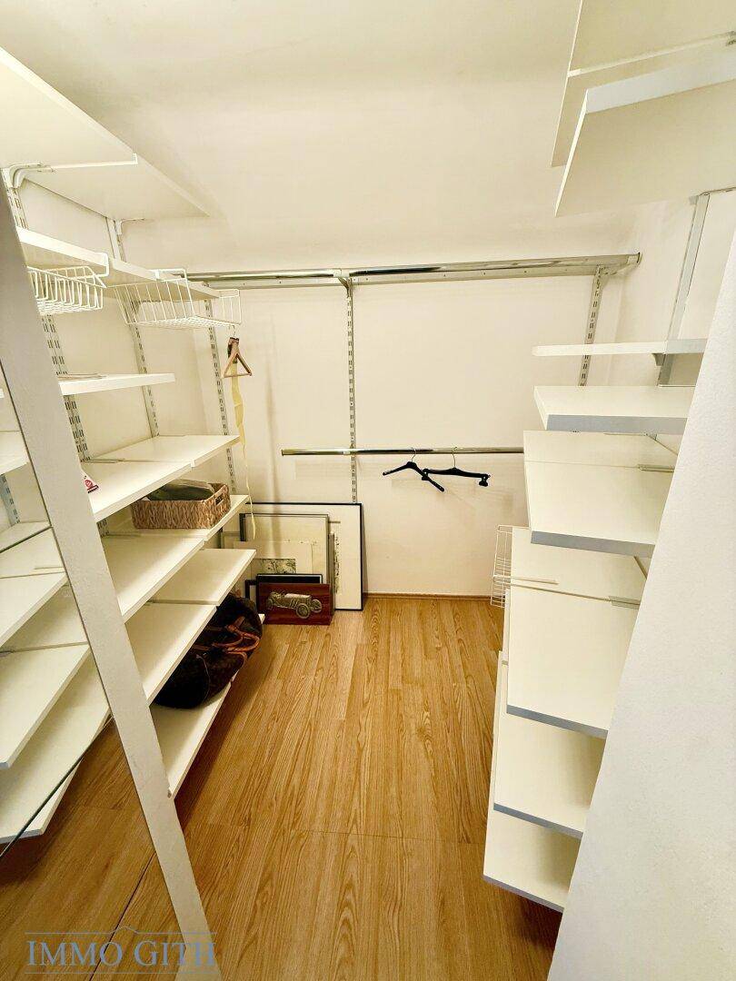 Praktischer begehbarer Kleiderschrank mit Regalsystemen und viel Stauraum für Kleidung und Accessoires.