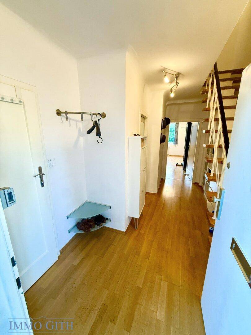 Eingangsbereich mit Garderobe, Schuhablage und hellem Parkettboden, führt zu den Wohnräumen.