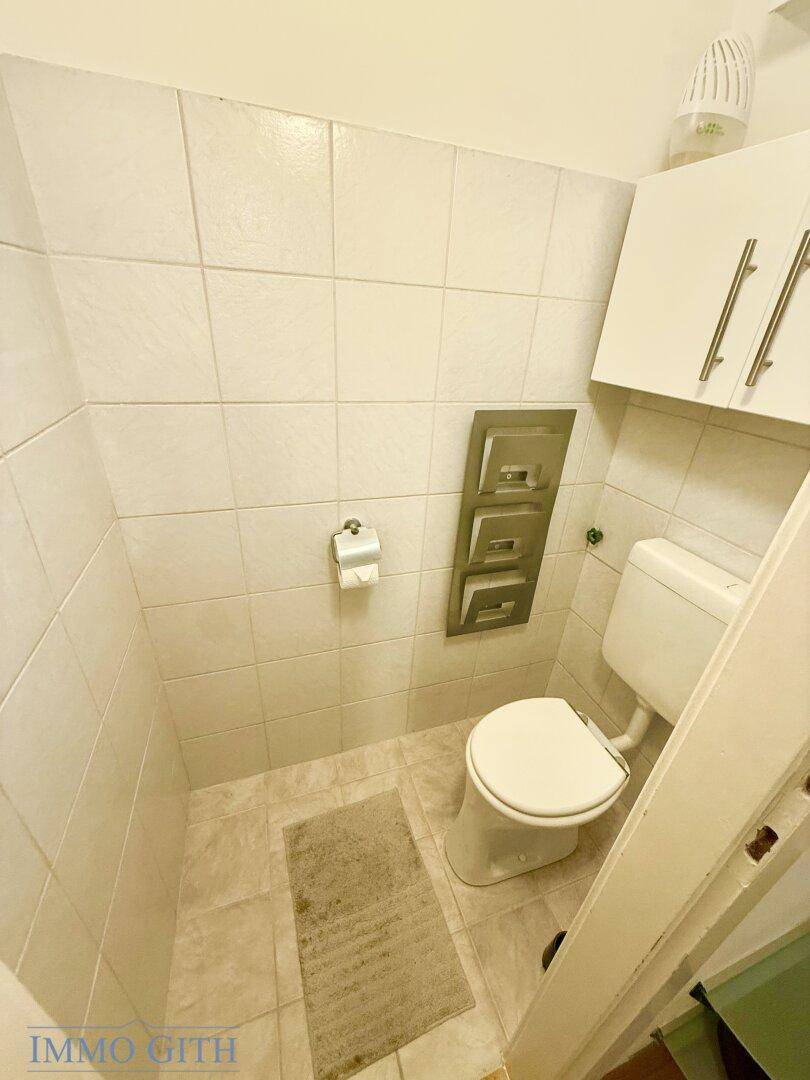 Kleines Gäste-WC mit Toilette und Fliesenboden, praktisch und funktional.