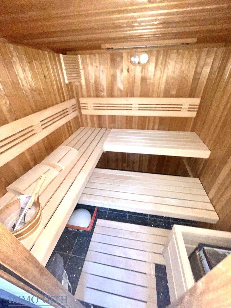 Private Sauna mit Holzverkleidung und mehrstufigen Sitzbänken für entspannende Momente.