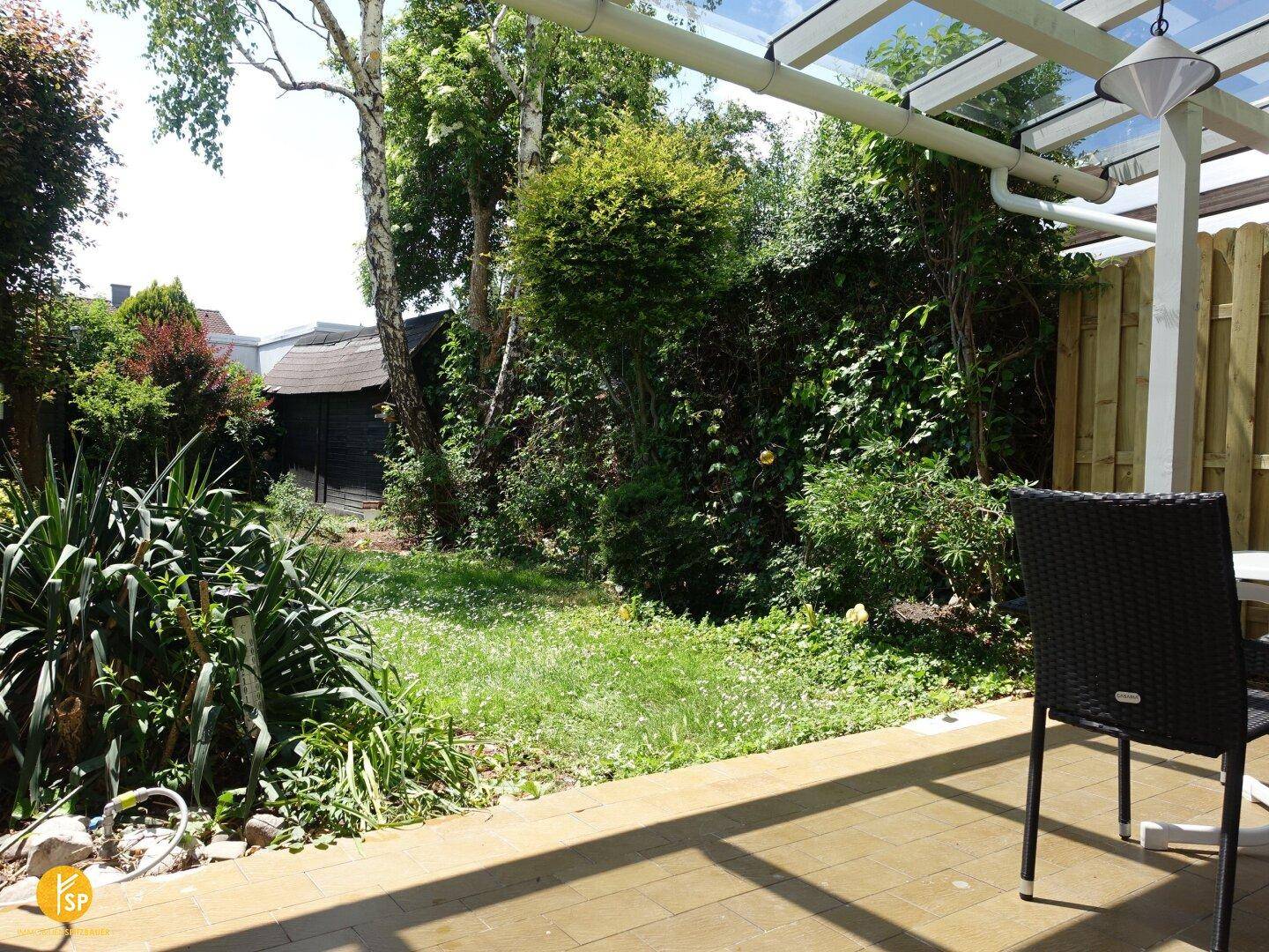 Gepflasterte Terrasse mit Gartenblick und einem Stuhl, ideal für entspannte Stunden im Freien.