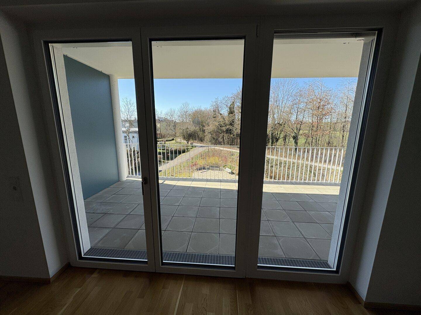 Große Fensterfront bietet Zugang zur Terrasse und einen weiten Blick ins Grüne.