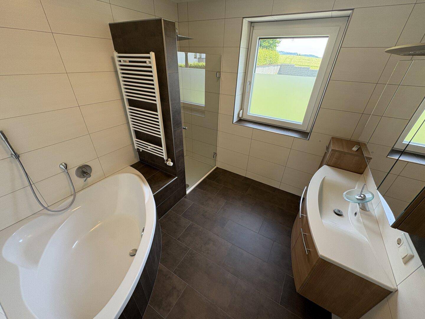 Modernes Badezimmer mit Badewanne, begehbarer Dusche, Einzelwaschbecken und Fenster.
