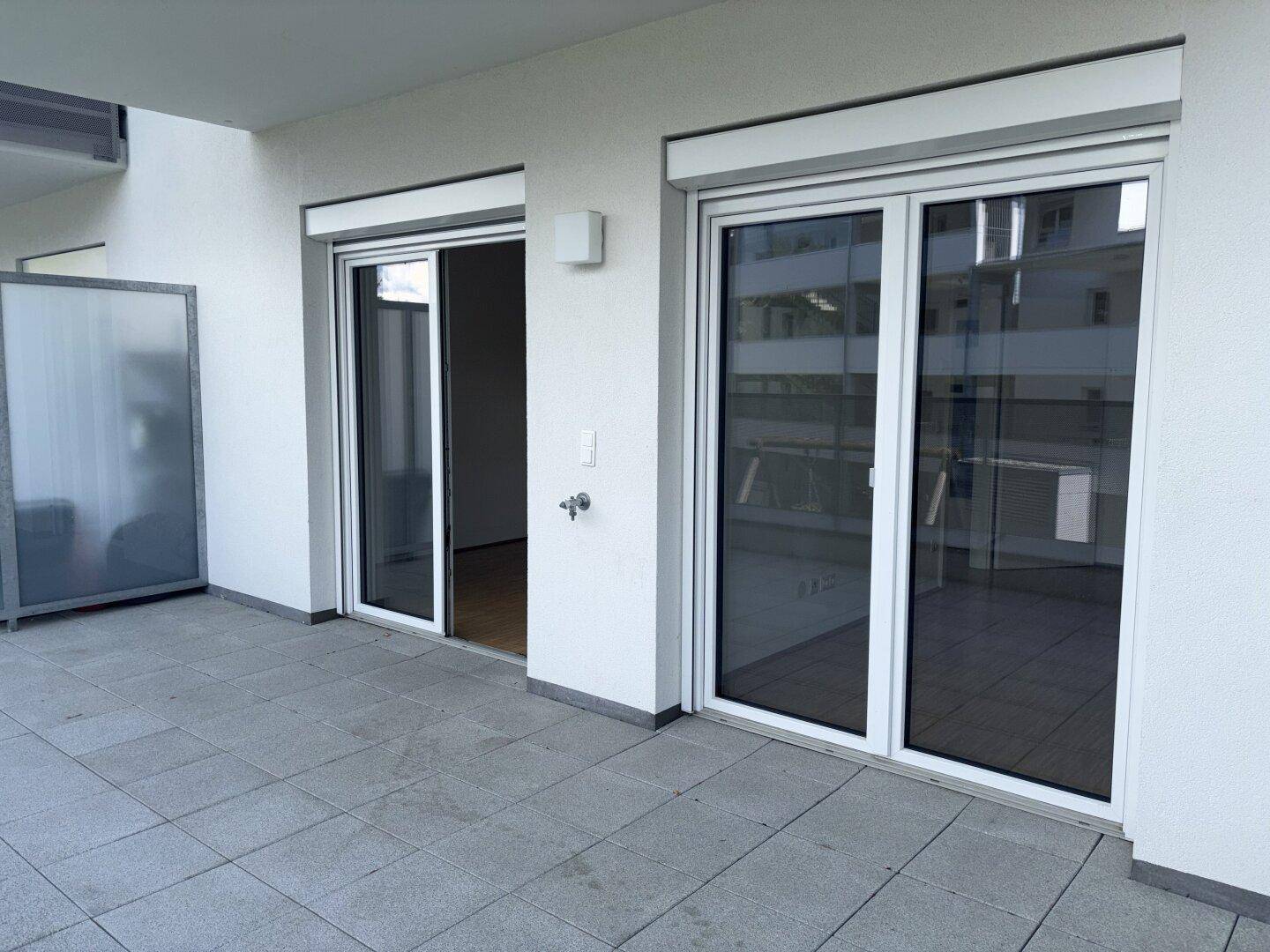 Geräumige Terrasse mit Schiebetüren, die Zugang zu den Innenräumen bieten.