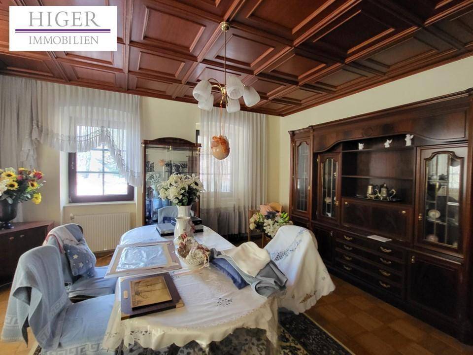 Traditionelles Esszimmer mit dunkler Holzvertäfelung an der Decke und passenden Möbeln.
