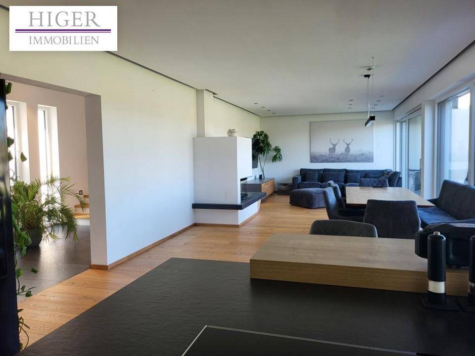 Geräumiger offener Wohn- und Essbereich mit Holzboden und Kamin, hell und modern eingerichtet.