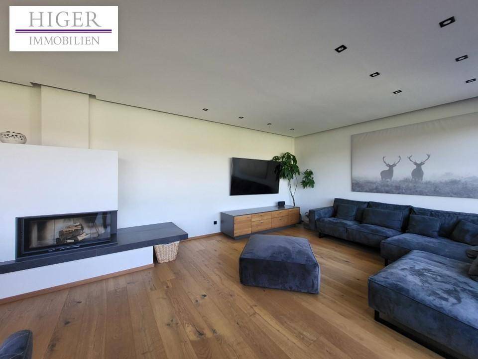 Gemütliches Wohnzimmer mit Kamin, großem Sofa und Holzboden, modern und hell gestaltet.