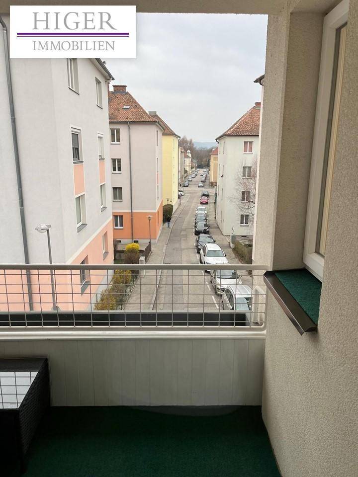 Balkon mit Blick auf die Straße und die umliegenden Gebäude der Wohngegend.