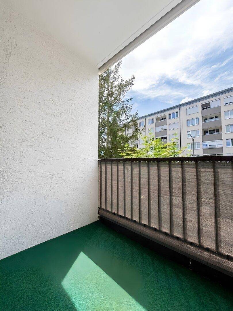 Gefliestes Badezimmer mit Duschkabine, Waschbecken und Waschmaschine.