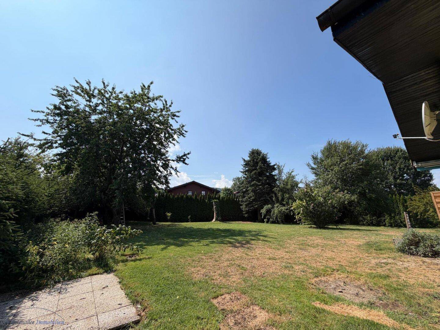 Großer, sonniger Garten mit altem Baumbestand und weitem Blick in die Natur.