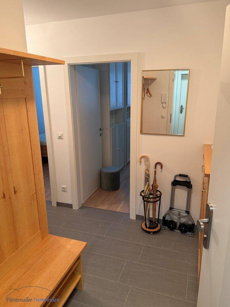 Eingangsbereich mit praktischer Garderobe aus Holz und pflegeleichten Fliesenboden.