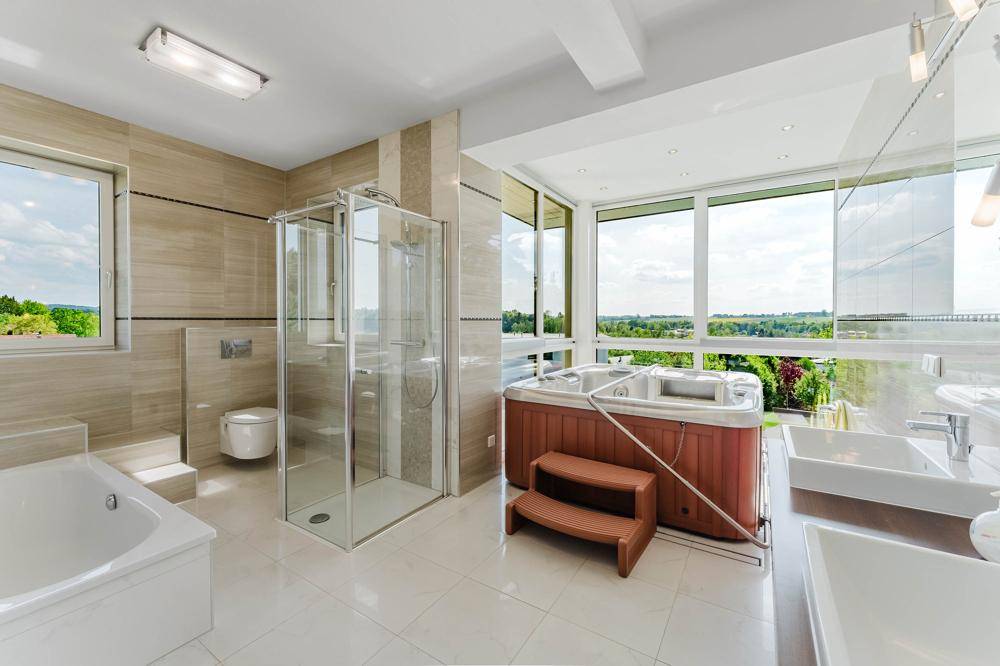 Großes Badezimmer mit Whirlpool, Dusche, Doppelwaschbecken und weitem Ausblick.