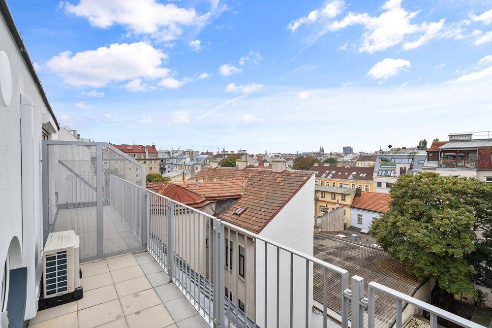 Langer Balkon mit Stadtblick und Klimaanlage-Außengerät, ideal für entspannte Stunden im Freien.